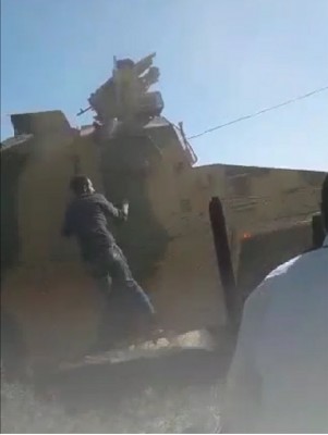 a_civilian_barehanded_protestor_tries_to_get_on_a_turkish_military_vehicle_which_drives_off_obs._av__ef_scr.shot_400